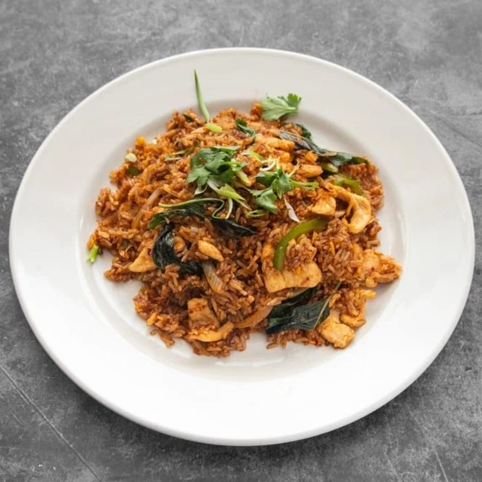Mai Thai Restaurant's Thai fried rice with chicken, basil, and cilantro on a white plate.