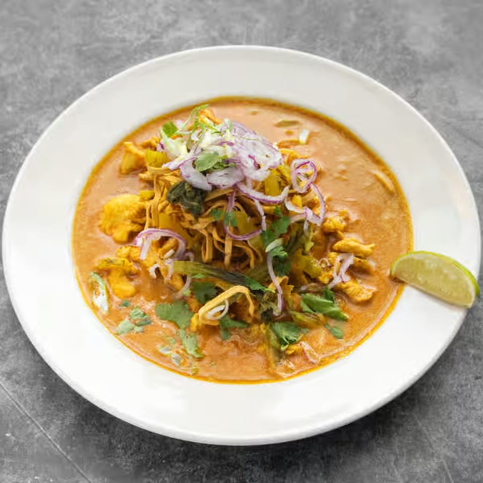 Mai Thai Restaurant's Khao Soi, a rich curry noodle soup with chicken, topped with red onions and cilantro.